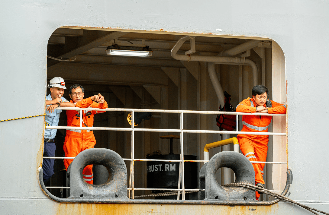 Captain in the cockpit monitoring cargo ship navigation systems